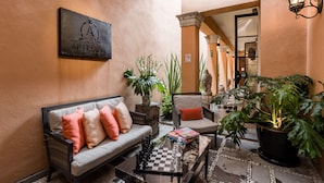 A cozy lounge area with a sofa, armchairs, a chessboard, and potted plants. - Artesana – Privately Owned Rosewood Residence (San Miguel de Allende)