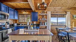 A wooden cabin kitchen with a central island, built-in appliances, and a view of the mountains. - Epic Views| 3 Pools!| Dog Friendly| Gatlinburg, GSMNP 10 Minutes (Gatlinburg)