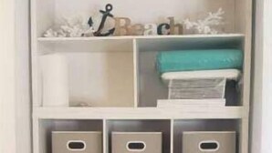 A white storage unit with multiple shelves and bins, some containing books and decorative items. - Hervana's Casa Blanca (St. Thomas)