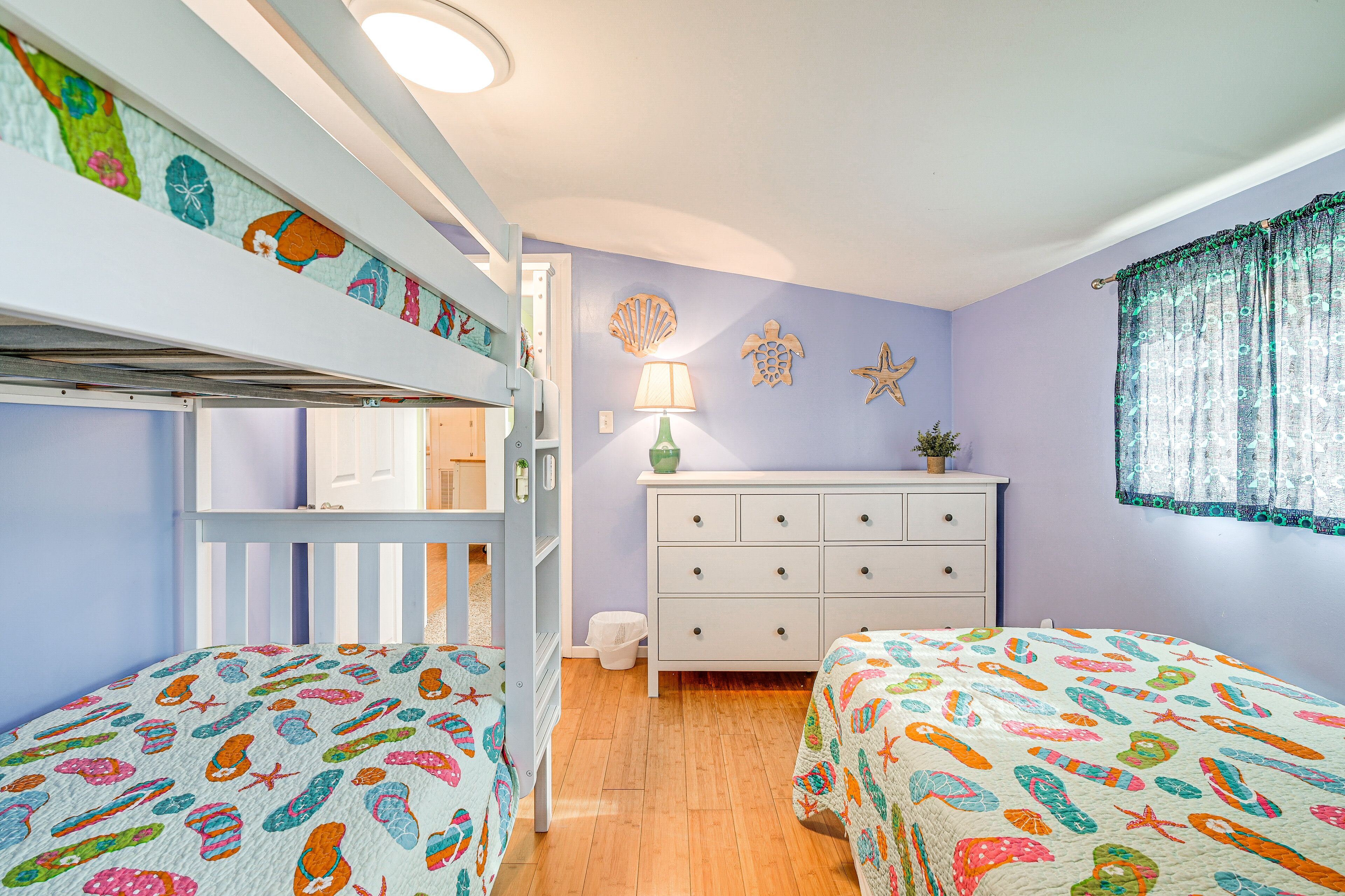 A bedroom with bunk beds, a dresser, and a lamp.