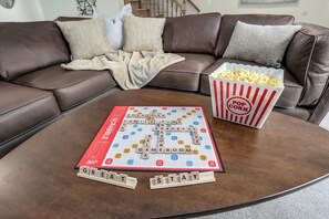 A board game on a coffee table with a popcorn bucket beside it.