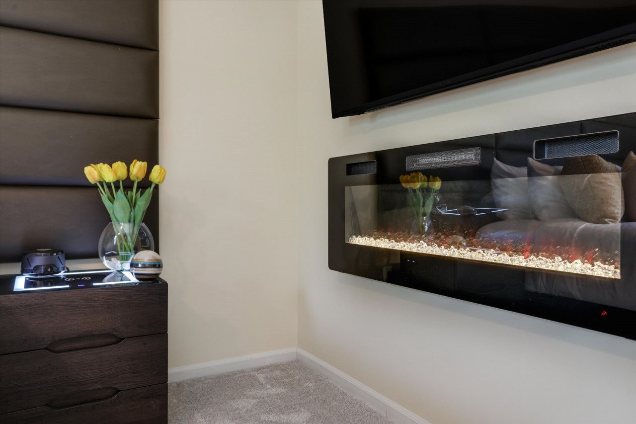 Ein modernes Zimmer mit einem großen Aquarium, einem Flachbildfernseher und einer dunklen Holzkommode mit Dekoration.
