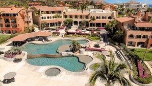 A resort with a central swimming pool, multiple buildings, and a mountainous backdrop. - ZOËTRY CASA DEL MAR 6 rounds Golf clinic/Spa/Wild Canyon/Wine & Cheese/Catamaran (San José del Cabo)