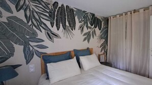 A bedroom with a bed, a headboard, a nightstand, a lamp, and a wardrobe.