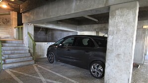 A parking garage with a car parked under a concrete pillar. - Studio 4/6pers, Terrasse, Jardinet, vue Imprenable sur la Muselle.50m des Pistes (Les Deux Alpes)