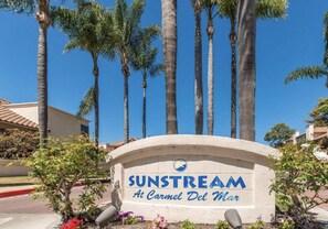 Experience the tranquil atmosphere of Sunstream Hotel, surrounded by lush palm trees and modern architecture.