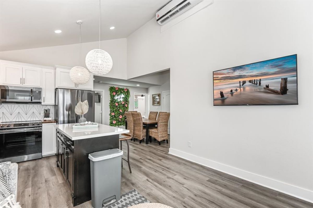 A modern kitchen with white cabinets, stainless steel appliances, and a central island.