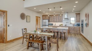 Una cocina amplia con armarios de madera, una isla central e iluminación colgante.