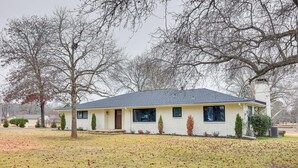 A single-story house with a gabled roof, a front porch, and a small front yard with leaf-covered ground. - Grand Lakefront Home in Hot Springs w/ Boat Dock! (Hot Springs)