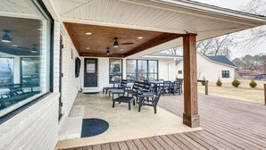 A covered patio area with outdoor seating, a ceiling fan, and a view of the surrounding neighborhood. - Grand Lakefront Home in Hot Springs w/ Boat Dock! (Hot Springs)