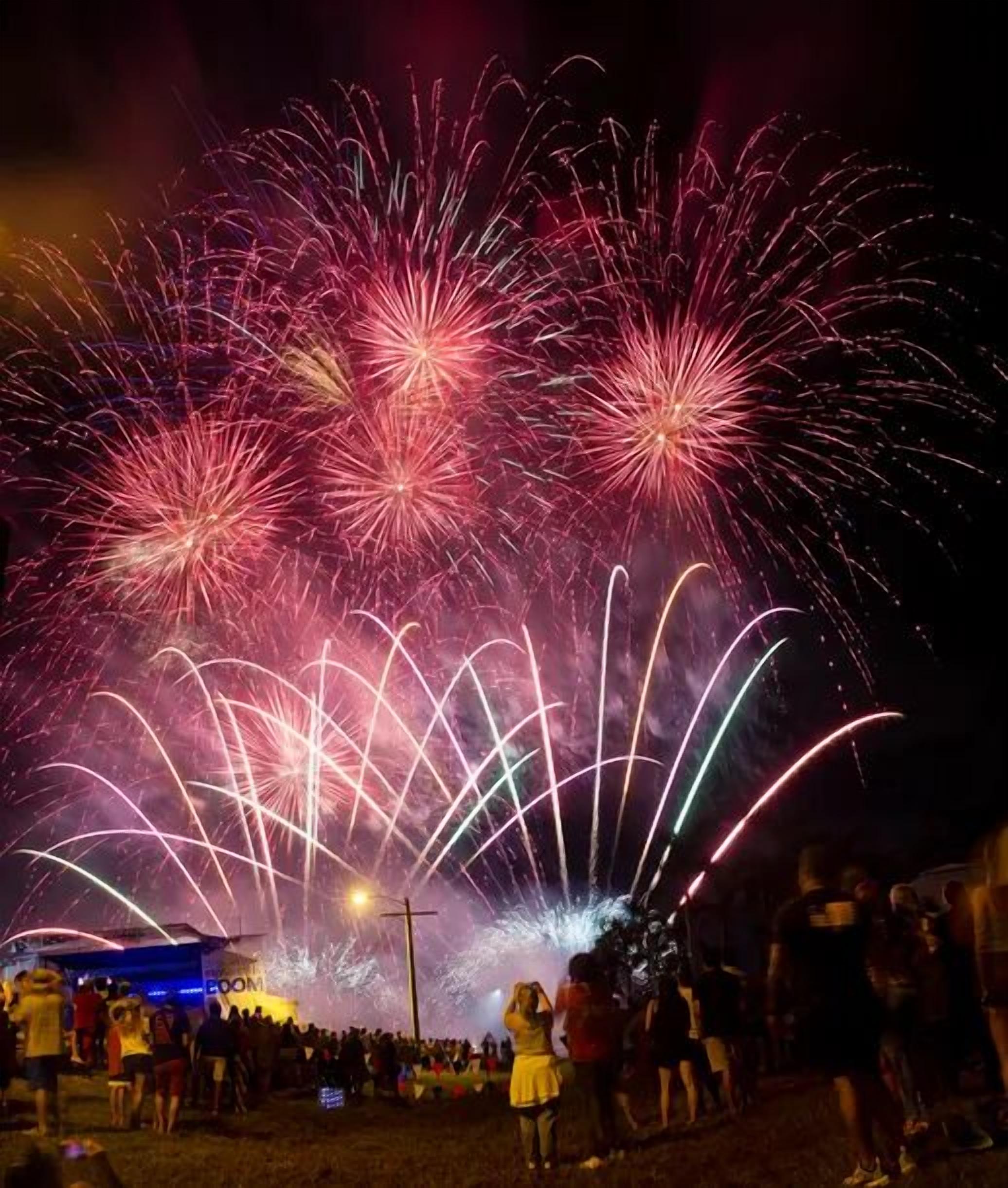 Evento nocturno al aire libre con fuegos artificiales.