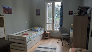 Un dormitorio con una cama individual, un escritorio, una silla y un armario.