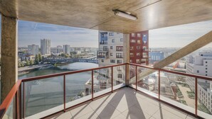 A high-rise building with a glass balcony overlooking a river and cityscape. - Charming Apartment With Panoramic Seine River & Eiffel Tower Views (Ivry-sur-Seine)