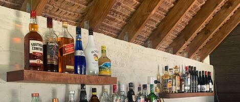 Una zona de bar con estantes de madera que exhiben varias botellas de licor.