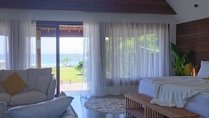 Ein Schlafzimmer mit Bett, Sofa und Meerblick.