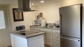 Eine moderne Küche mit einem Edelstahlkühlschrank, einem Einbauofen und einem Spülbecken.
