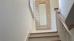 Eine Treppe mit Holzbodenstufen und einem weißen Geländer.