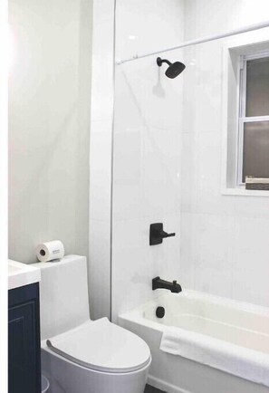 Bathroom features a bathtub, shower, and toilet.