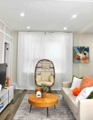 Relax in this stylish living room with a comfortable chair, sofa, and flat-screen TV.