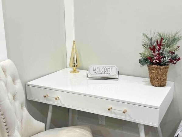 Relax in a serene space with a console desk, leather chair, and a beautiful plant.