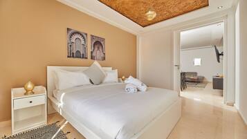A modern bedroom with a large bed, a nightstand, and a ceiling with a textured design.