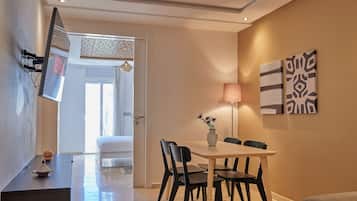Un espace repas moderne comprenant une table, des chaises et un vase de fleurs.