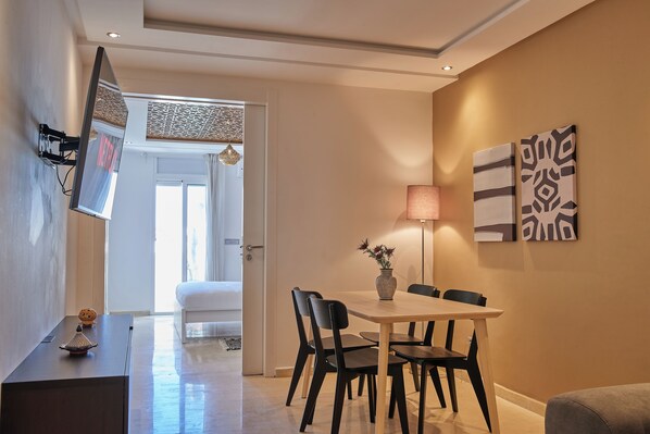 A modern dining area with a table, chairs, and a vase of flowers.