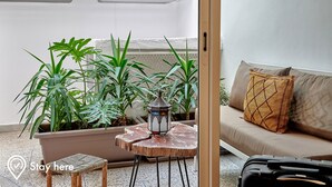 A room with a sofa, a small table with a lantern, and potted plants. - Stayhere Rabat - Hassan Heritage (Rabat)