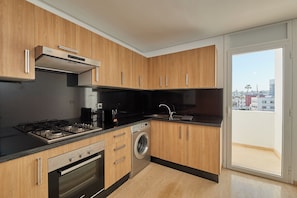 A modern kitchen with wooden cabinets, a Bosch washing machine, and a gas stove. - Stayhere Rabat - Hassan Heritage (Rabat)