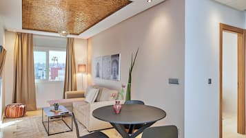 Una sala de estar moderna con una mesa redonda, un sofá y un techo decorativo.
