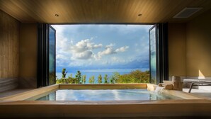A modern spa room with a large window offering a view of the sea and sky.