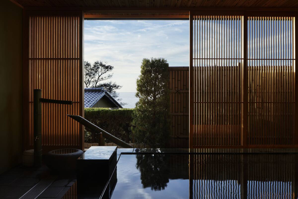 A traditional Japanese room with tatami flooring, a low table, and sliding doors.