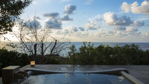 A hot tub with a view of the sea and sky.