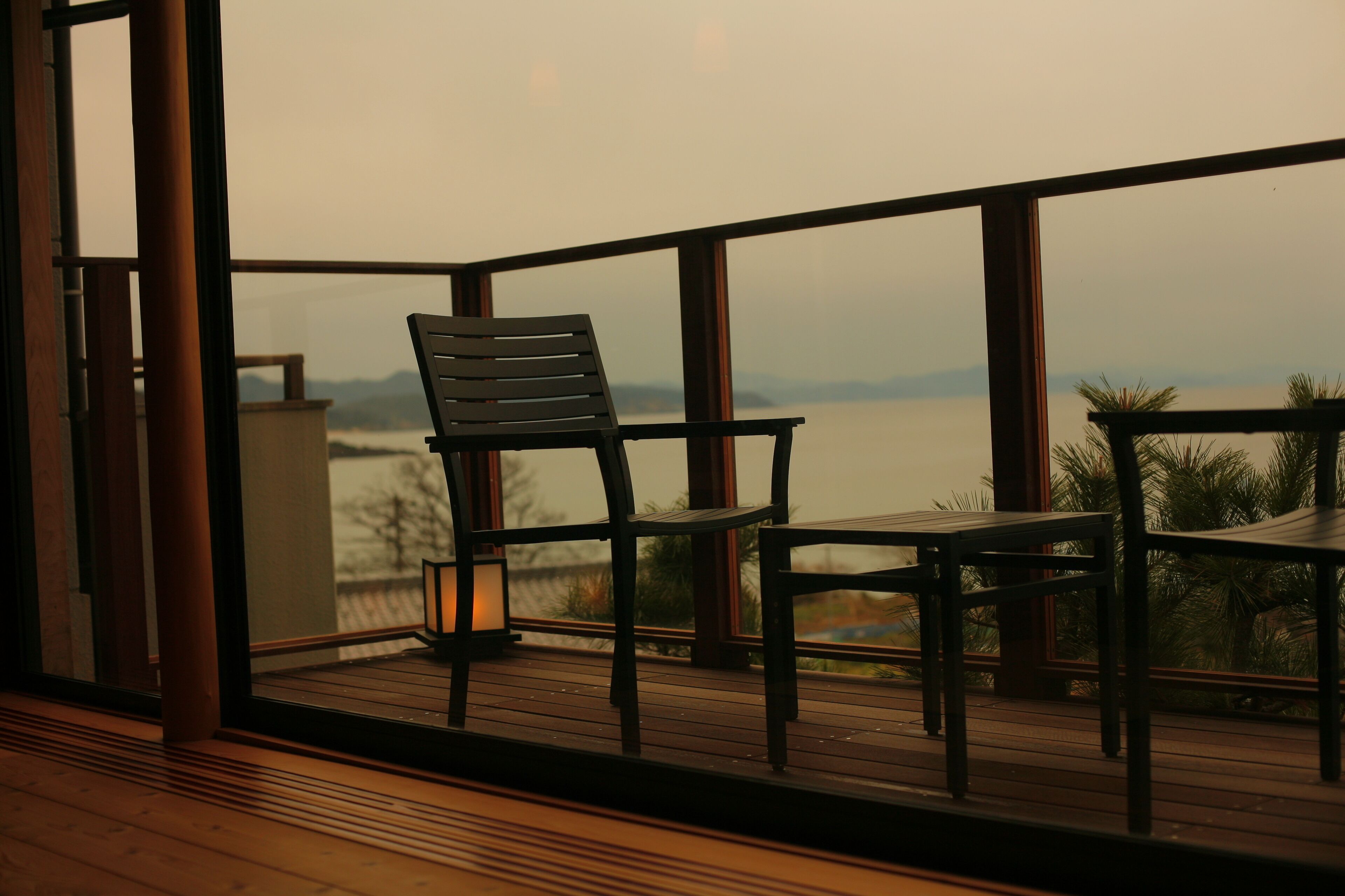 Un balcon avec un plancher en bois, une chaise et une table.
