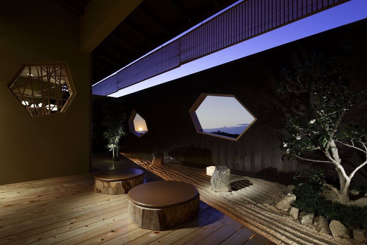 A modern interior with hexagonal windows, wooden flooring, and a unique ceiling design.