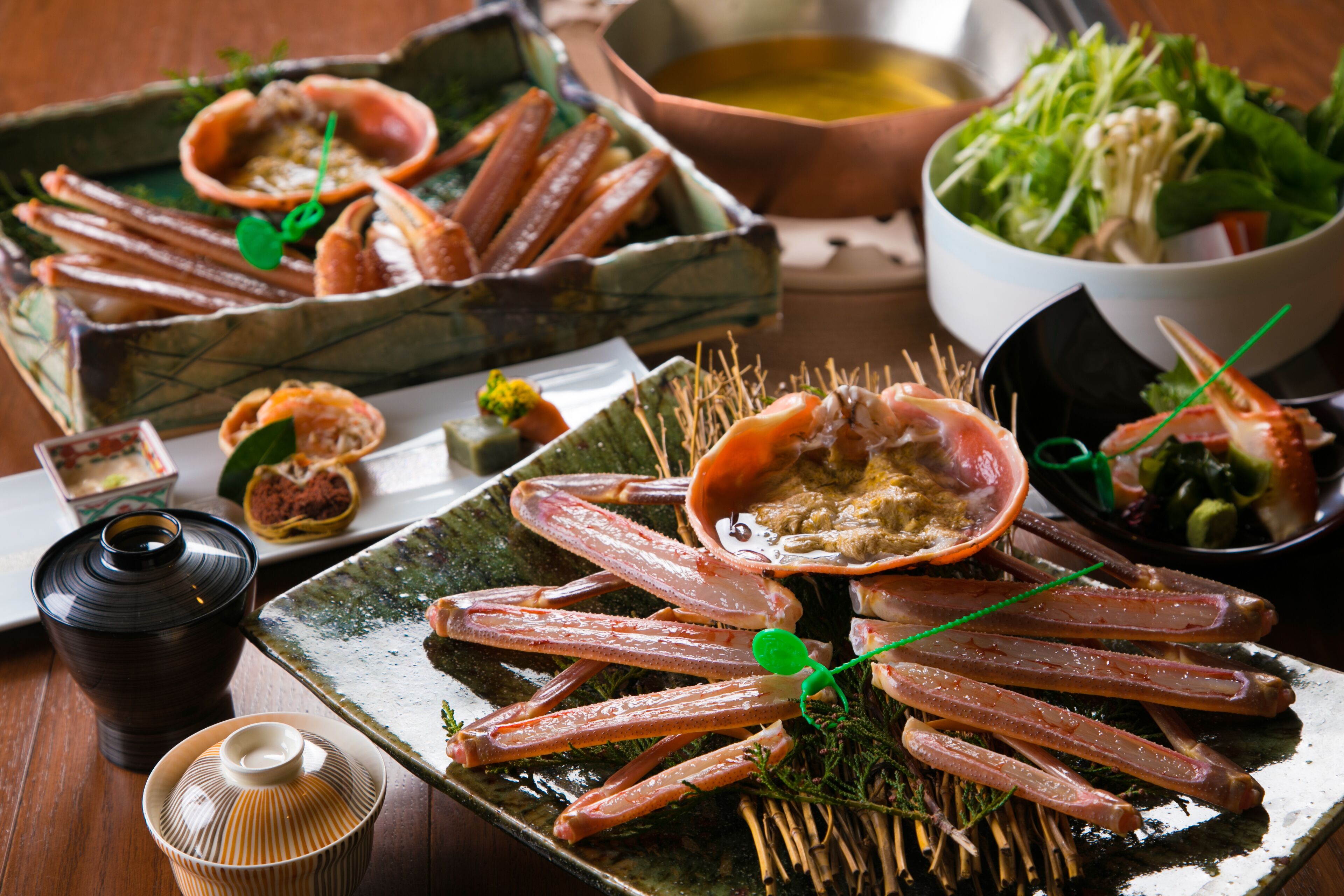 A dining table with seafood dishes, including crab legs and a bowl of salad.