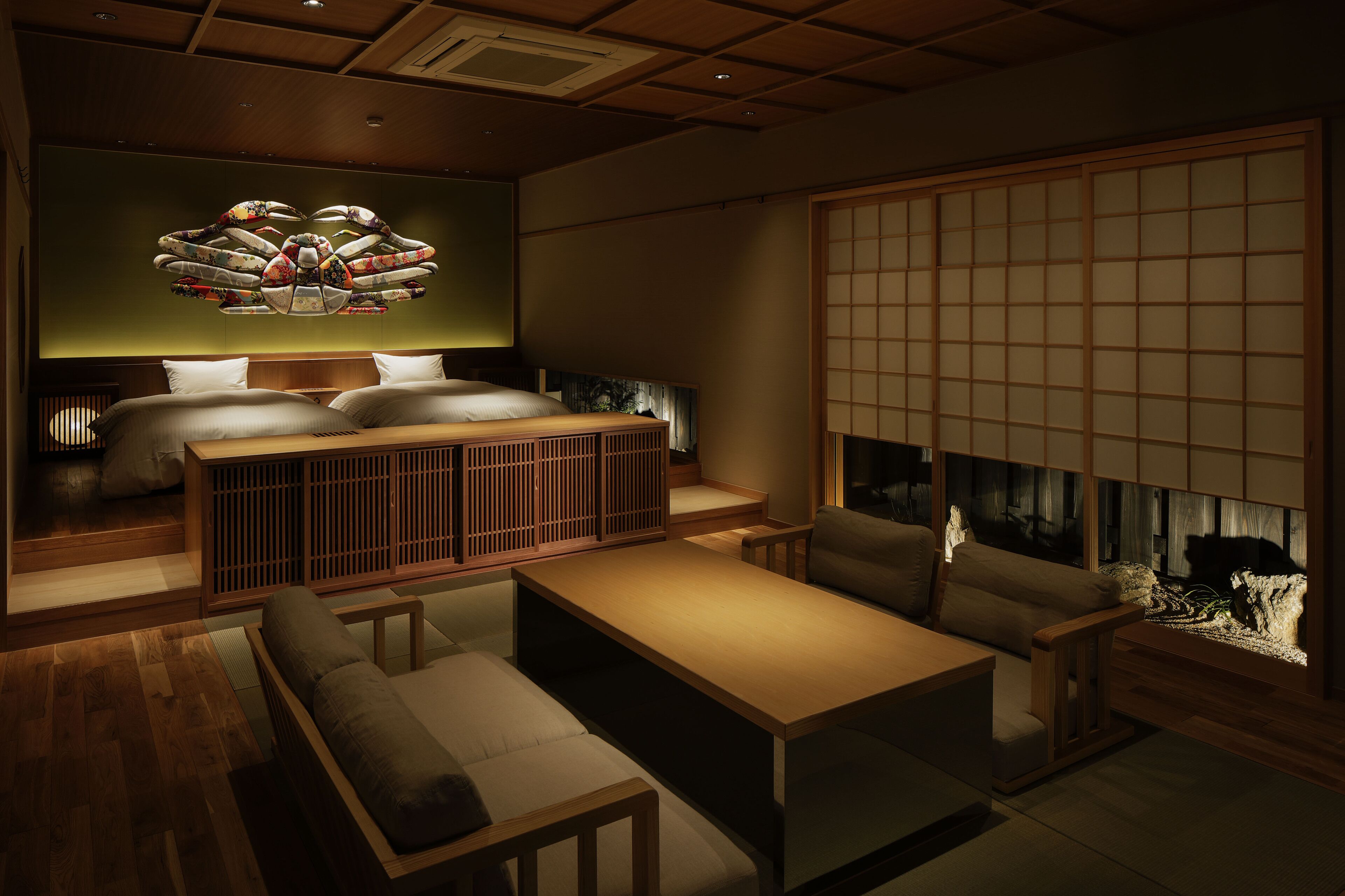Une pièce de style japonais traditionnel, avec un sol recouvert de tatamis, un lit bas en bois, un espace de détente sur tatamis et un paravent shoji.