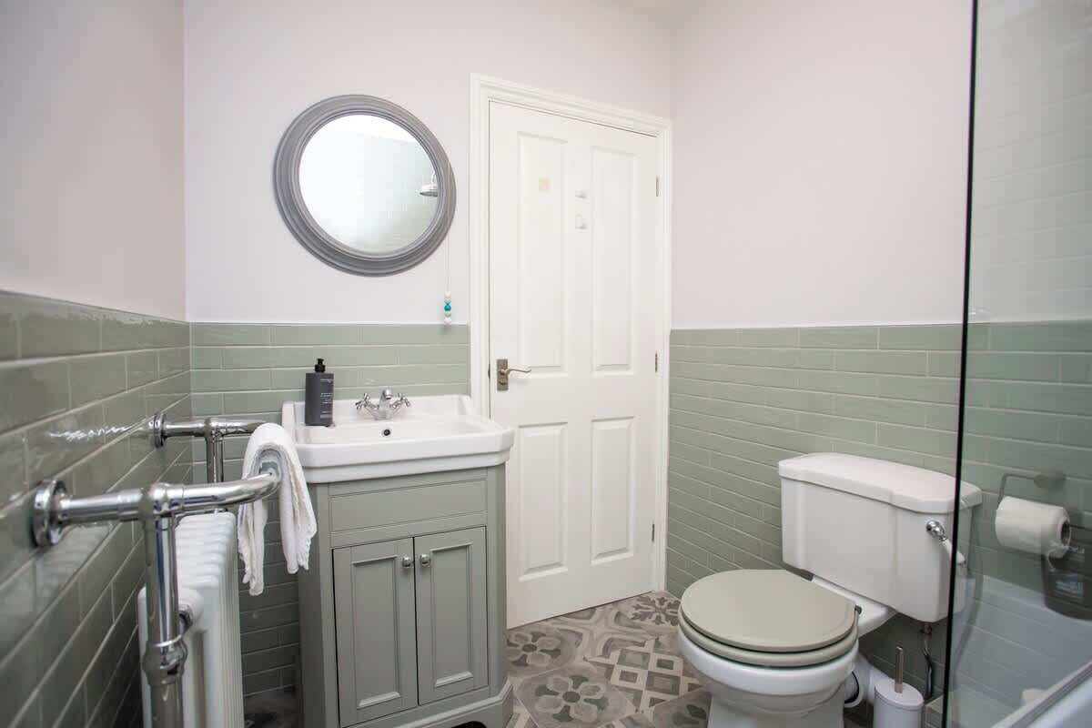 Een badkamer met toilet, wastafel en spiegel.
