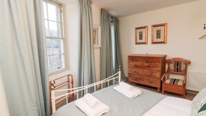 A bedroom with a bed, a dresser, a chair, and a window with curtains. - Upper Oakwood (Alnwick)