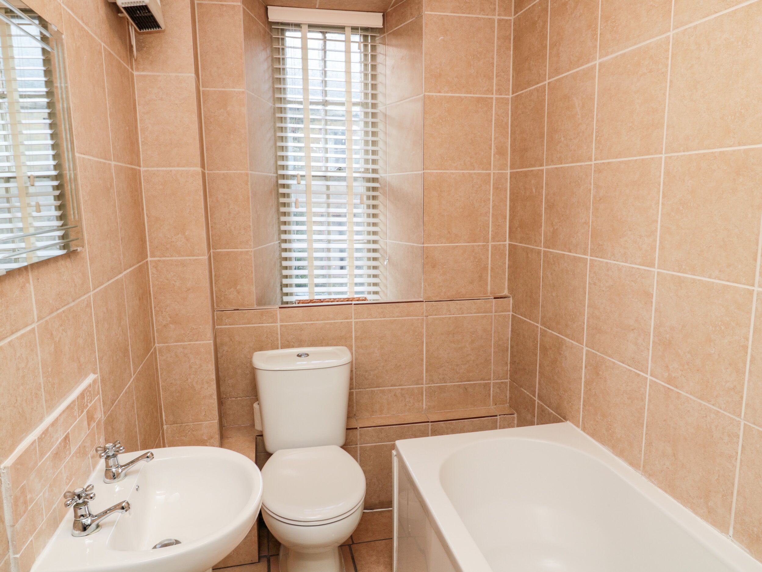 A bathroom with a toilet, sink, and bathtub.