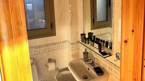 Un baño con inodoro, lavamanos y ventana.