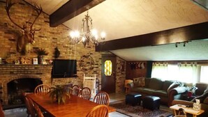 A spacious living room with a fireplace, a dining area with a wooden table and chairs, and a cozy seating area with a sofa and armchairs. - Lake Charles #1 Rental located close to everything. Casino's/mall/restaurants.  (Lake Charles)
