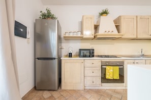 A modern kitchen with a stainless steel refrigerator, microwave, oven, and a sink. - Holiday Home 'Girasole' with Private Terrace, Garden and Air Conditioning (Pula)