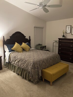 A bedroom with a bed, a bench, a dresser, a ceiling fan, and a window with blinds. - Walk to Sawgrass: Cottage Villa 2/2 - Glass Lanai/Privacy Fence, Pets Welcome! (The Villages)