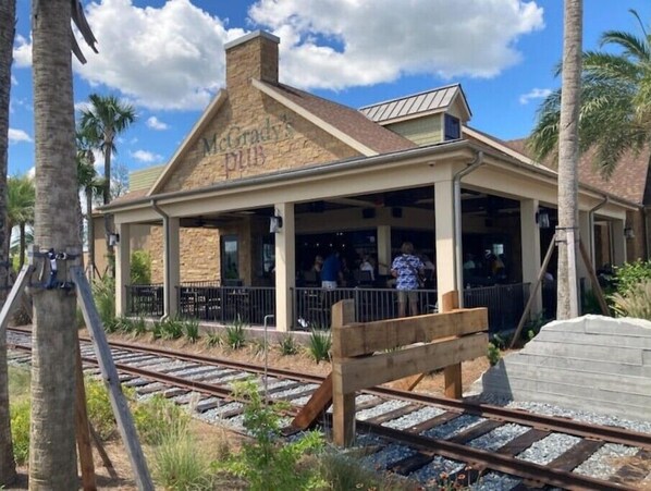 A building labeled "McGrady's Pub" with a covered outdoor seating area and a wooden bench.