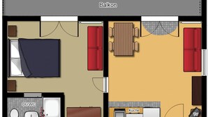 Ein Hotelzimmer mit Balkon, einer Sitzecke inklusive Tisch und Stühlen, einer Küchenzeile und einem Badezimmer.