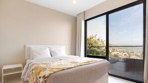 A bedroom with a large window, a bed, a bedside table, and a view of a cityscape. - Holiday Home 'Dream View' with Sea View, Private Terrace & Wi-Fi (Funchal)