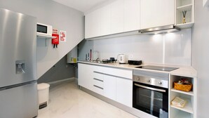 A modern kitchen with stainless steel appliances, white cabinetry, and a built-in oven. - Holiday Home 'Dream View' with Sea View, Private Terrace & Wi-Fi (Funchal)