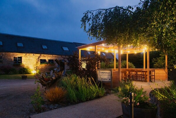 A covered outdoor seating area with a sign reading 'Bienvenue' and a reception direction.