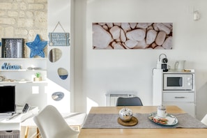 Una cucina moderna con forno a microonde, bollitore e macchina del caffè sul piano di lavoro.